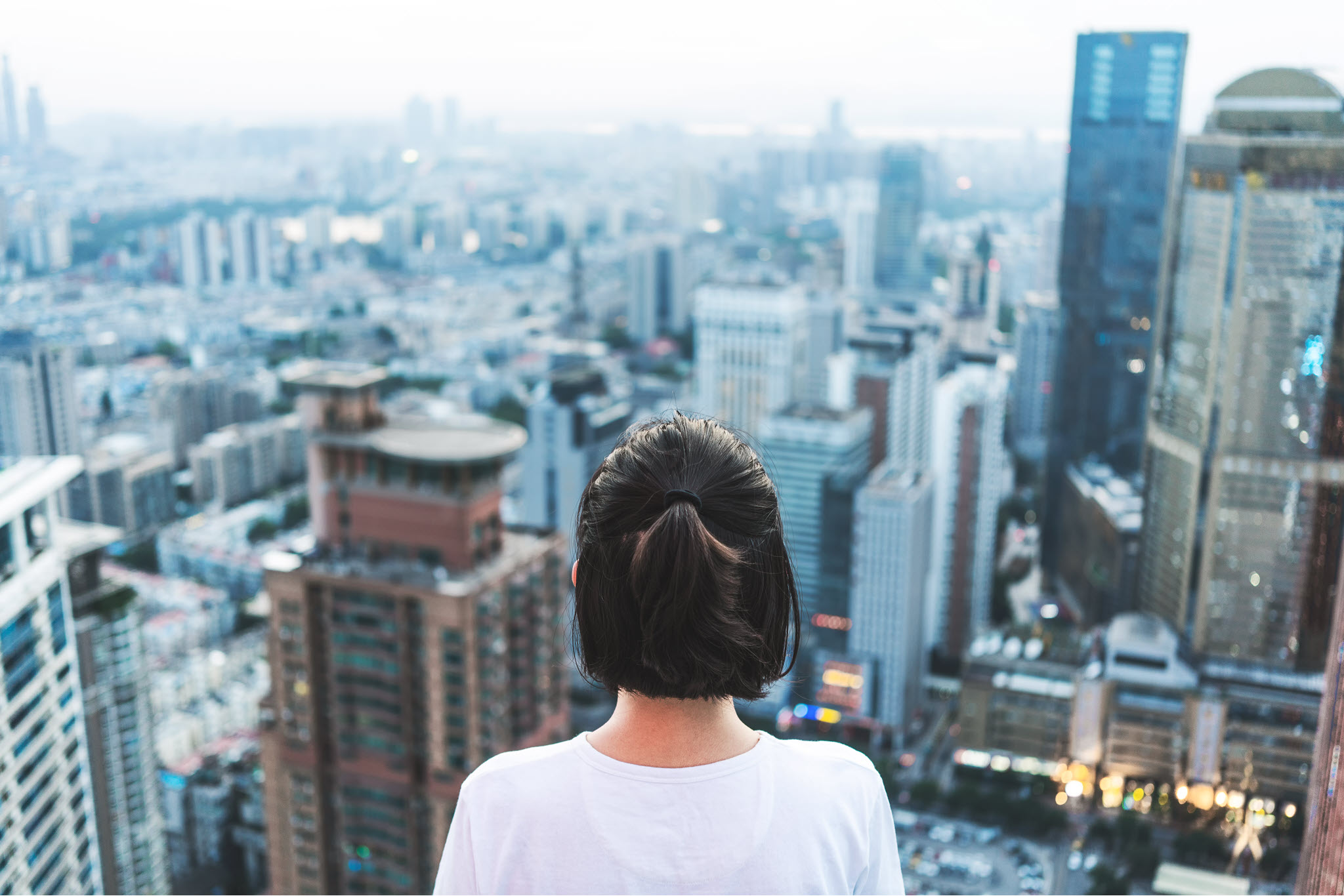 Young woman seen from her back, looking at the cityscape.