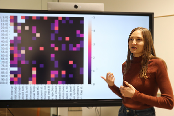 A woman presenting in front of a projection screen