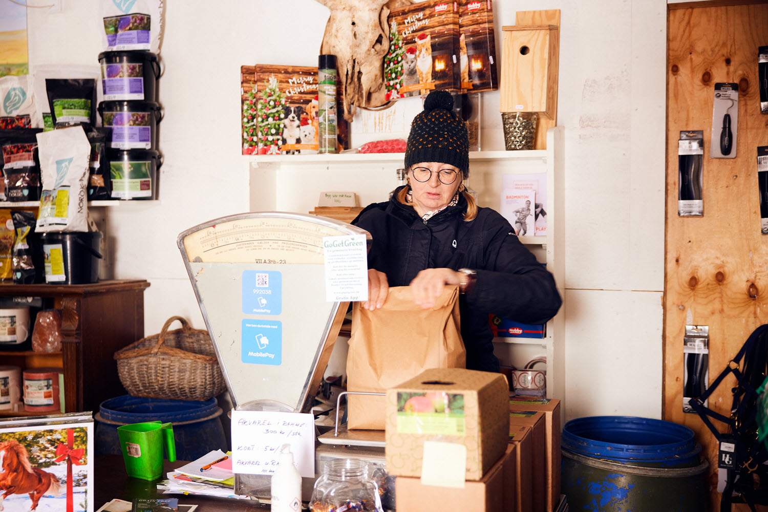 Marian weighing a bag on an old fashioned grocery store weight scale