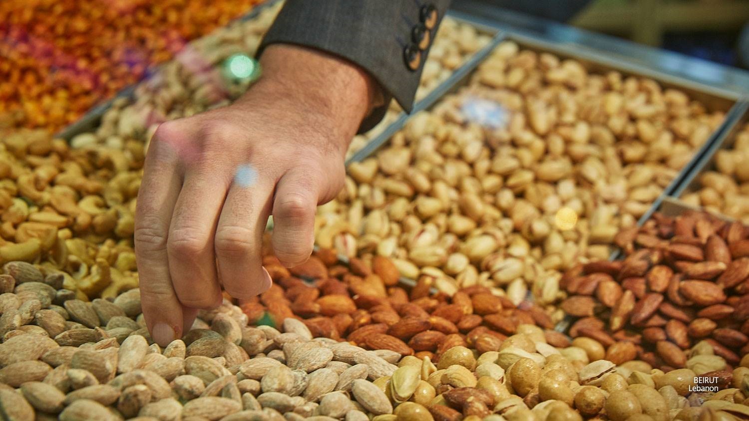 Hand taking almonds at the market