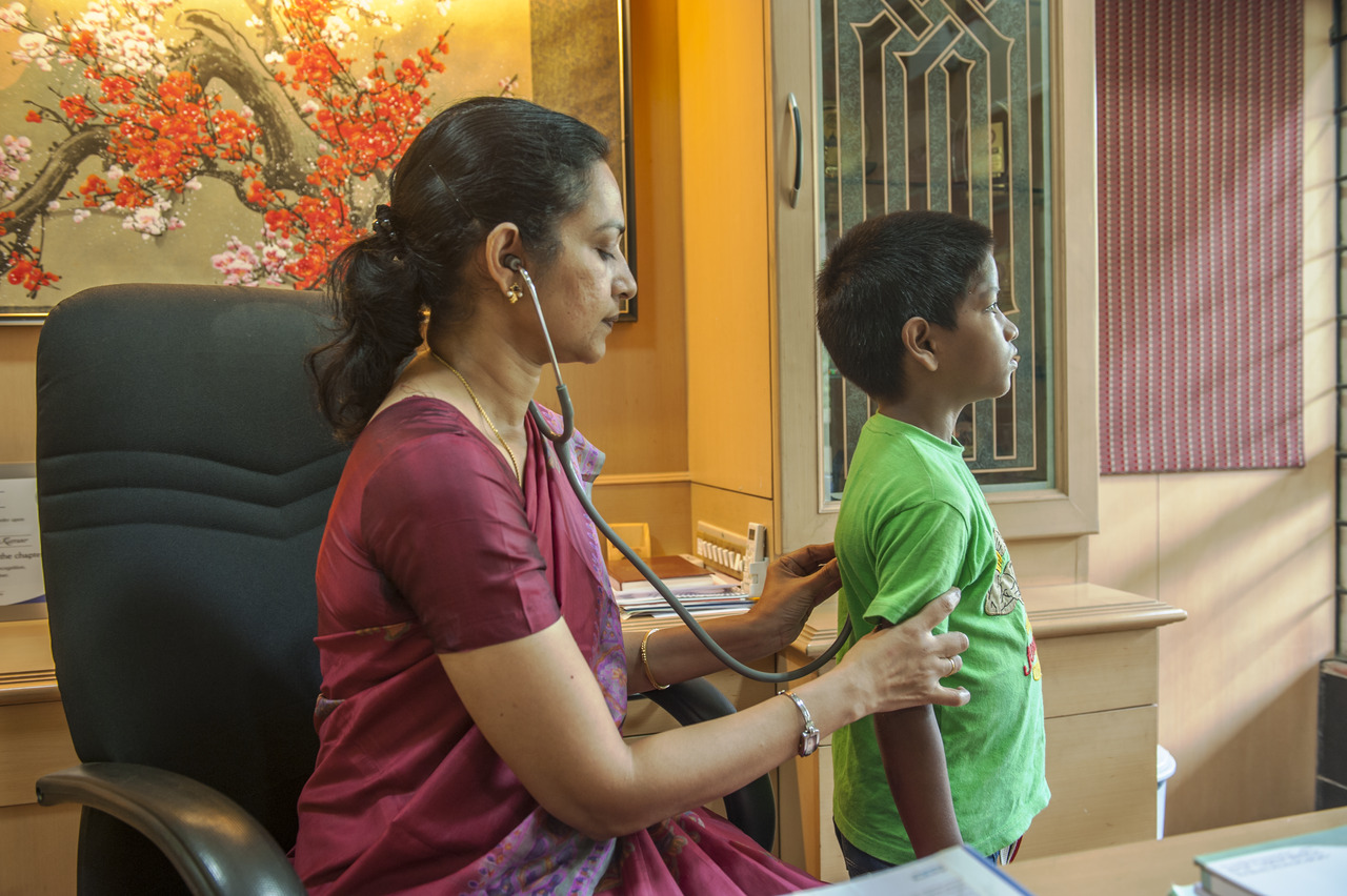 A doctor listening to a child's breathing with a stethascope